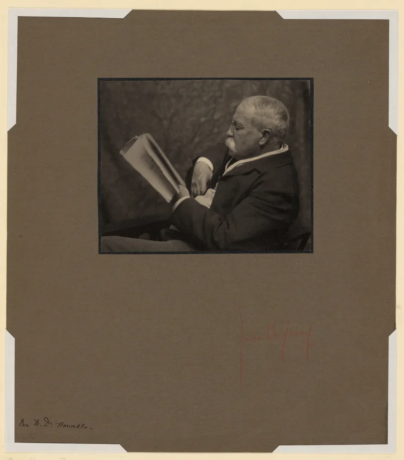 Monochrome studio portrait of the writer William Dean Howells, seated, in a dark suit, looking slightly away from the camera.